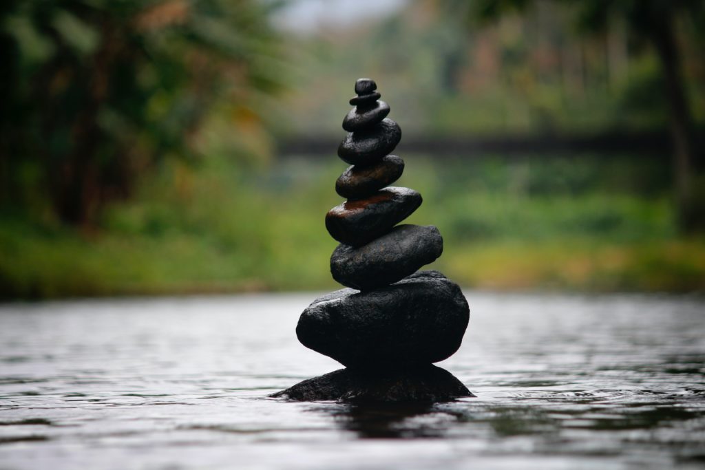 zen like black rocks stacked on the river 